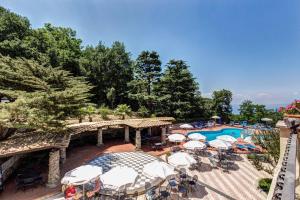a resort with a pool and a bridge with umbrellas at Grand Hotel Hermitage in SantʼAgata sui Due Golfi