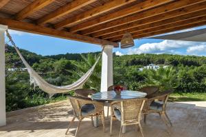 una mesa y sillas en un patio con hamaca en Can Torres en Santa Eularia des Riu