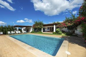 a swimming pool in front of a house at Can Torres in Santa Eularia des Riu
