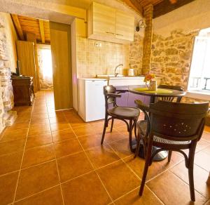 a kitchen with a table and chairs and a sink at Guesthouse Merla in Šibenik