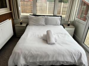 um quarto com uma grande cama branca e 2 janelas em Park Cottage em Scunthorpe