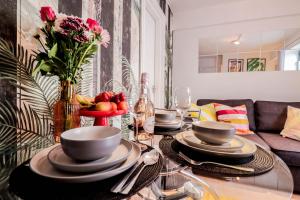 a table with plates and bowls of fruit on it at Steps to Oxford Street-Central 1BR Flat Sleeps 4 in London