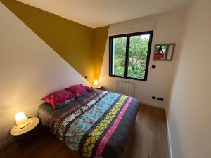 1 dormitorio con cama y ventana en Maison proche plages, en Clohars-Fouesnant