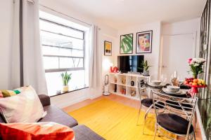 a living room with a couch and a table at Steps to Oxford Street-Central 1BR Flat Sleeps 4 in London