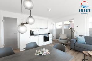 Il comprend une cuisine et un salon avec une table et un canapé. dans l'établissement Haus Billstrasse 231 - Wohnung 1, à Juist