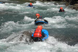 a group of people in the rapids of a river at Camping Llavorsi in Llavorsí