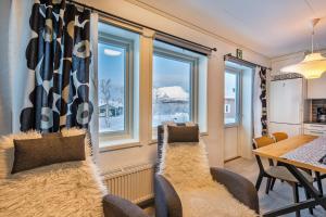 a dining room with a table and chairs and windows at Ahma Mökki in Kilpisjärvi