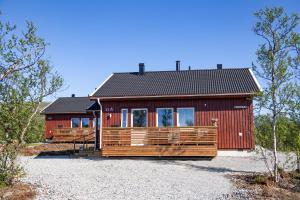 una casa rossa con tetto nero di Ahma Mökki a Kilpisjärvi