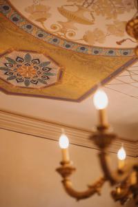un techo artesonado con una pintura en el techo en Hotel Oviv dimora del borgo, en Acquaviva Picena