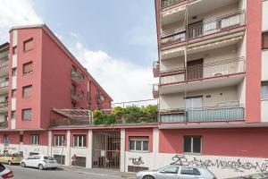 un edificio rosa con graffiti sul lato di Cobra apartment Gdarco si trova a 600 mt dalla stazione e metropolitana di Sesto Fs a Sesto San Giovanni