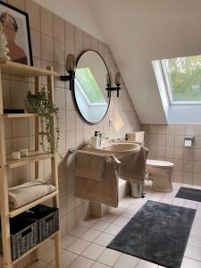 a bathroom with a sink and a mirror and a toilet at Ferienwohnung Skandi in Bad Eilsen