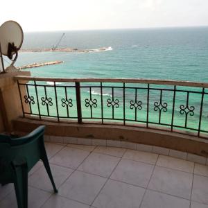 Eine Frau auf einem Balkon mit Meerblick in der Unterkunft الاسكندريه خالد بن الوليد in Alexandria