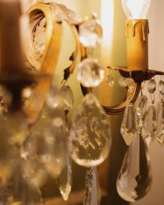 a chandelier with wine glasses and a candle at Hotel Oviv dimora del borgo in Acquaviva Picena