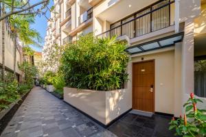 a walkway in front of a building with plants at Cross Vibe Paasha Atelier Bali Kuta in Kuta