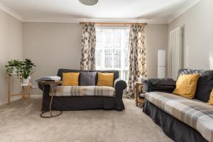 Una sala de estar con un sofá y una ventana. en Cosy Roseburn Apartment, Edinburgh - 2 Bedrooms, FREE PARKING, en Edimburgo