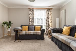 - un salon avec un canapé et une fenêtre dans l'établissement Modern Two Bedroom Apartment, Roseburn, Edinburgh - Free Parking, à Édimbourg