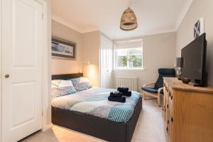 Un pequeño dormitorio con una cama y un televisor. en Cosy Roseburn Apartment, Edinburgh - 2 Bedrooms, FREE PARKING, en Edimburgo