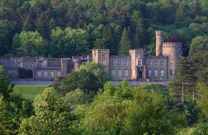 an old castle with trees in front of it at Lakeside 3 Bedroom Bungalow Retreat Merthyr Tydfil in Cefn-coed-y-cymmer