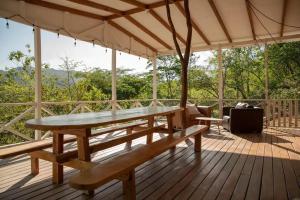 - une terrasse en bois avec une table et des bancs dans l'établissement Villas La Paillote Costa Rica, à Puntarenas