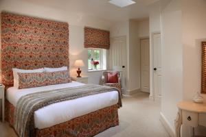 a bedroom with a large bed and a chair at Stone Lodge at Combermere Abbey in Nantwich