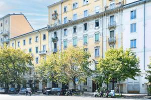 duży żółty budynek z drzewami przed nim w obiekcie RELSTAY - Washington Street w Mediolanie