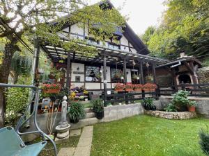 a house with a flower shop in the yard at Pensiunea Eugenia in Bran