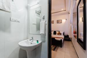 ein weißes Badezimmer mit einem Waschbecken und einem Spiegel in der Unterkunft The Legend Haveli in Jaisalmer