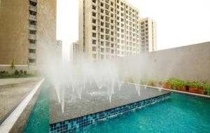 a water fountain on the side of a building at Studio Flat Near Airport in Surat