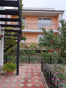 ogród z ogrodzeniem i kwiatami przed budynkiem w obiekcie Eleon w mieście Humań