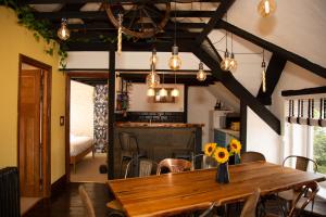 a dining room with a wooden table and a kitchen at Quirky Boutique 1840s Stable in Torquay