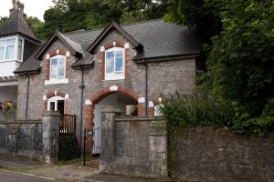 a brick house with a gate and a fence at Quirky Boutique 1840s Stable in Torquay