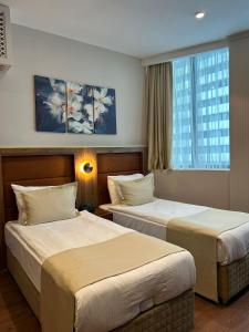 a hotel room with two beds and a window at Sky Tower Hotel in Batumi