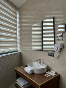 y baño con lavabo y espejo. en Sky Tower Hotel en Batumi