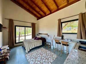 um quarto com uma cama, uma mesa e cadeiras em Canastra - Chalés Canário de Minas em São João Batista do Glória