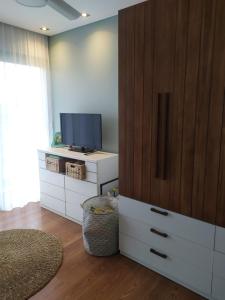 Una sala de estar con televisión y un gran mueble de madera. en Tranquilidad plena y Termas., en Villa Elisa