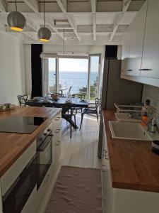 a kitchen and dining room with a view of the ocean at TY KERLUZ in Locquirec