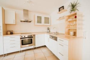 a kitchen with white cabinets and a stove top oven at MaTi´s Appartment 