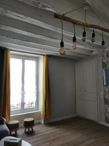 sala de estar con techo de madera y 2 ventanas en Maison Chaleureuse dans petite cité de caractère en Fresnay-sur-Sarthe