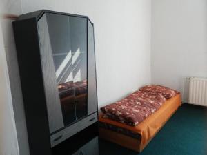 una camera da letto con cassettiera, letto e specchio di Ubytovna u hospůdky a Ostrava