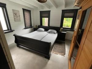 een slaapkamer met een groot bed in een kamer met ramen bij De Genten 2 in Ermelo