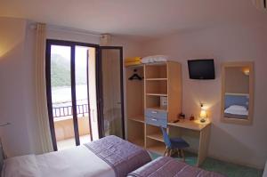 a bedroom with a bed and a desk at Brise de Mer in Porto Ota