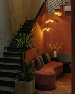 a living room with a couch and a staircase at KIN WANDER - Tân Phong in Ho Chi Minh City