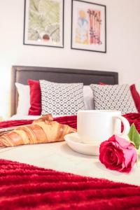 a table with a cup and a rose on a bed at Steps to Oxford Street-Central 1BR Flat Sleeps 4 in London