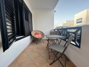 a balcony with chairs and a table and a basket at Oasis Famara a 20 m de la playa in Famara
