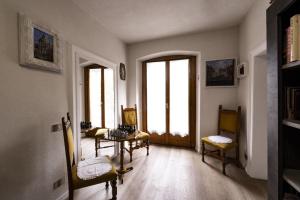 a living room with chairs and a table and windows at Palazzo Cervesato Appartamento: Maria Luisa in Santo Stefano di Cadore