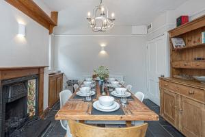 a dining room with a table and a fireplace at Character Townhouse in Town Centre & Superb Views in Dolgellau