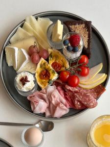 une assiette de fromage et d’autres denrées alimentaires sur une table dans l'établissement STADTQUARTIER Windischeschenbach, à Windischeschenbach