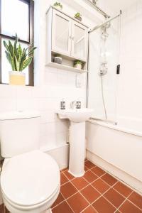 a bathroom with a toilet and a sink and a tub at Steps to Oxford Street-Central 1BR Flat Sleeps 4 in London