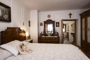 a bedroom with a large bed and a cross on the wall at Palazzo Cervesato Appartamento: Maria Luisa in Santo Stefano di Cadore