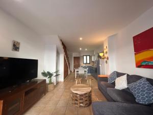 a living room with a couch and a tv at Oasis Famara a 20 m de la playa in Famara